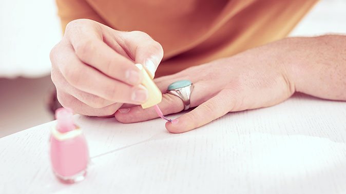 covering his nails attractive ginger queer person wearing big silver ring painting short small nails with baby pink polish